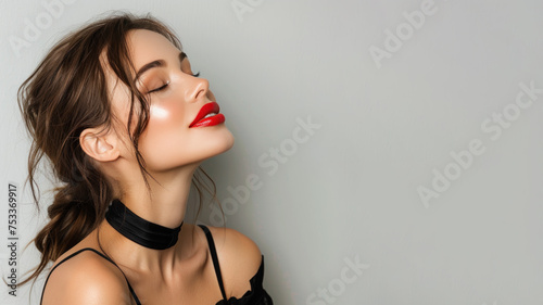 Brunette woman wearing black criss cross dress smile isolated on gray photo