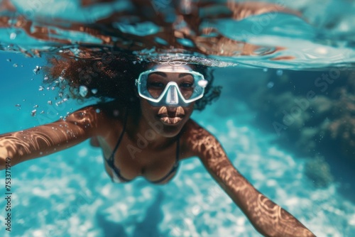 Underwater view of an African American woman snorkeling, facing the camera. Suitable for travel, adventure, and sports themes.