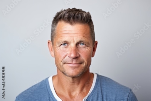 Portrait of a handsome mature man looking at camera over grey background