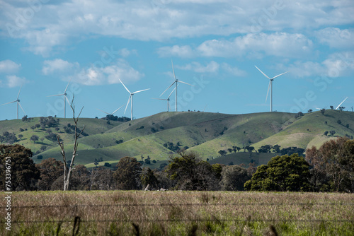 wind turbines farm on greens hills  with blur sky and white clouds
