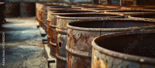 Rusty barrels lining up in rows.