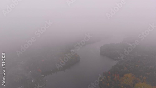 Wallpaper Mural Drone shot emerging from the clouds to reveal a stunning river surrounded by autumn colored trees Torontodigital.ca