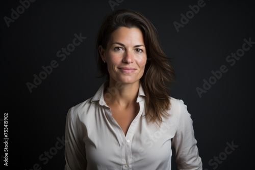 Portrait of a beautiful businesswoman on a dark background. Studio shot.