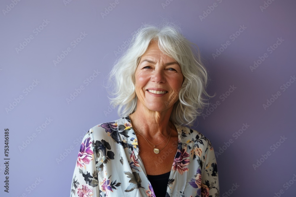 Portrait of a happy senior woman smiling at the camera against a purple background Portrait of a happy senior woman smiling at the camera against a purple background