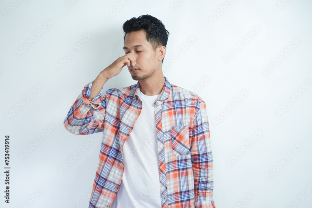 Adult Asian man closed his nose with hand when smell something bad Adult Asian man closed his nose with hand when smell something bad