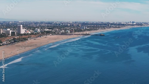 Drone shot panning to the right overlooking the santa monica beach and pier