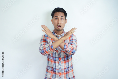 Adult Asian man wearing flannel shirt making stop hand sign with serious expression photo