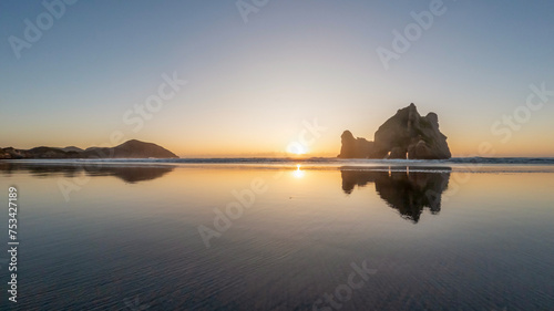 Golden Hour Serenity: Sunset Landscape Overlooking Wharariki Beach and the Tasman Sea, South Island, New Zealand photo
