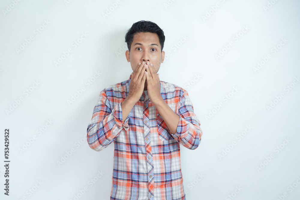 Adult Asian man covering his mouth showing shocked expression Adult Asian man covering his mouth showing shocked expression