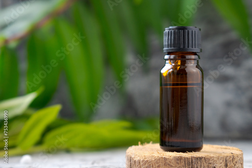 A bottle o essential oil is sitting on a wooden surface