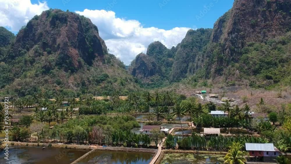 Aerial of beautiful hidden gem Rammang Rammang Village with giant limestone cliffs and huge karst mountains in Sulawesi, Indonesia.