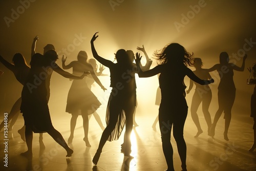 A group of women are dancing in a dimly lit room