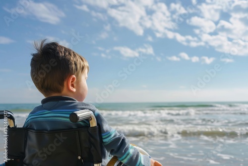 Low angle shot of a disabled child looking out at the ocean