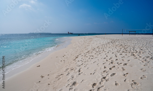 Nice sea coast with a sandy beach and a seaplane on the surface.