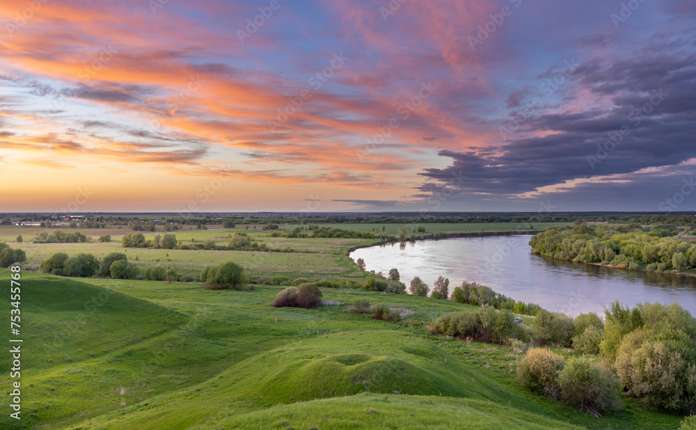 dramatic sky, colorful sunset, river bend against green field background, sunset landscape