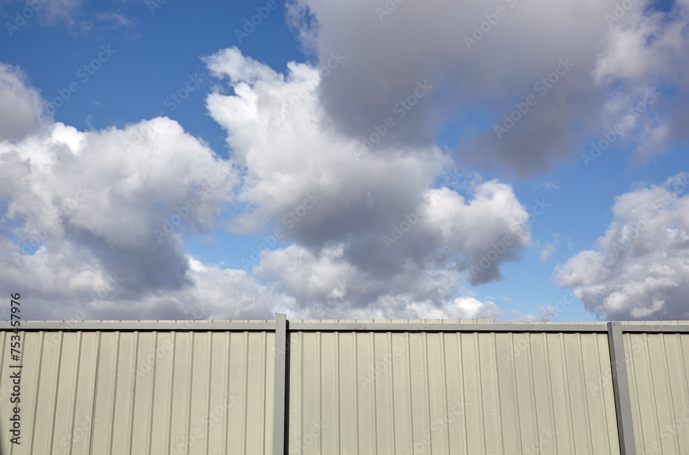 Corrugated steel fence against blue sky. Corrugated metal texture surface or galvanize steel