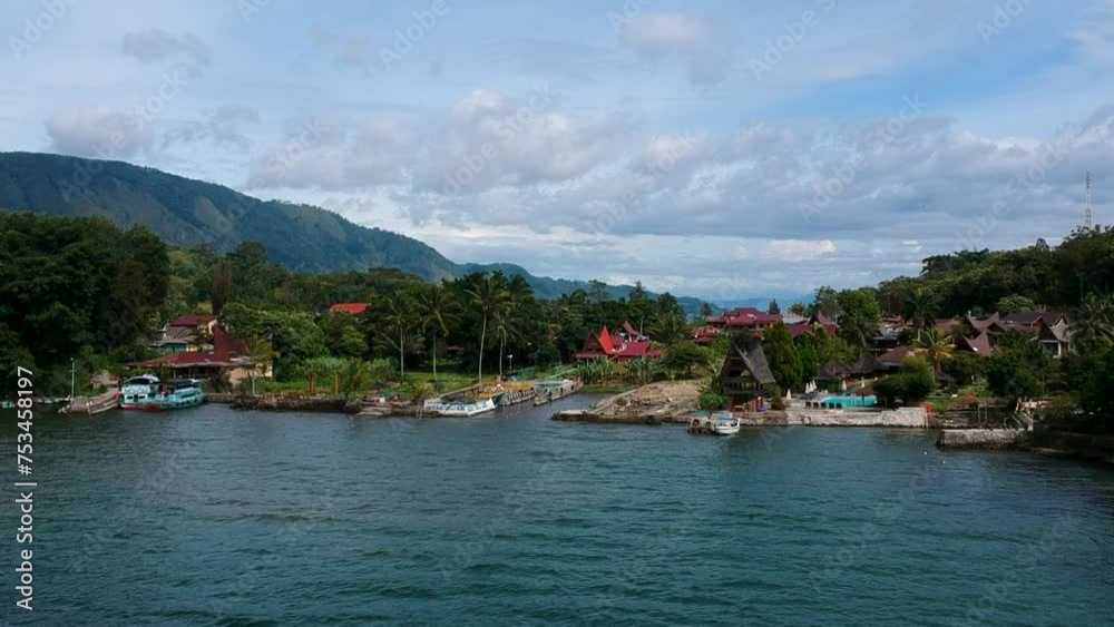 Aerial drone of Lake Toba with village, mountains, and blue water in Sumatra, Indonesia. Aerial drone of Lake Toba with village, mountains, and blue water in Sumatra, Indonesia.