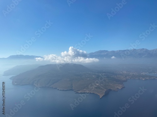 top view of an island in the sea with clouds and mountains