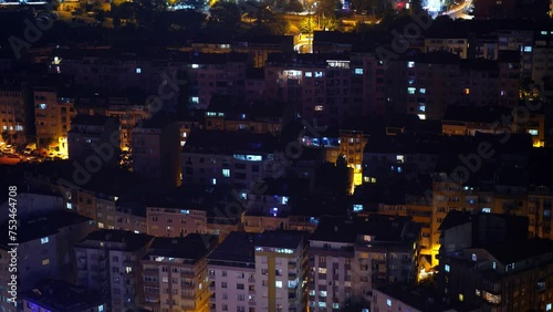 Istanbul's densely built-up old residential quarter, windows twinkle on and off on dark buildings. Time-lapse shot, view from above, late at night. As city is falling asleep more windows become black photo