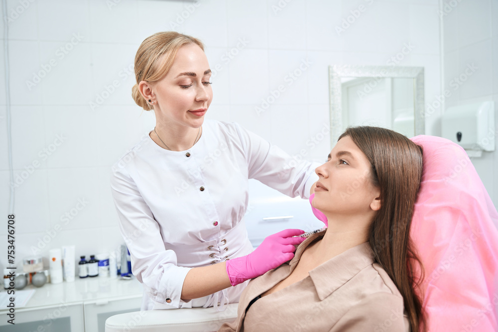 Fototapeta premium Medical worker on cosmetology procedure with client