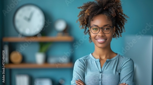 A woman wearing glasses standing in front of a clock