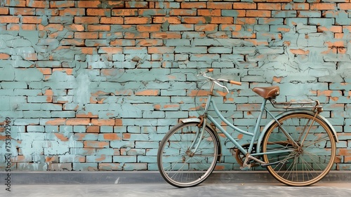An antique bicycle by the side of the road with an old brick wall backdrop © tongpatong