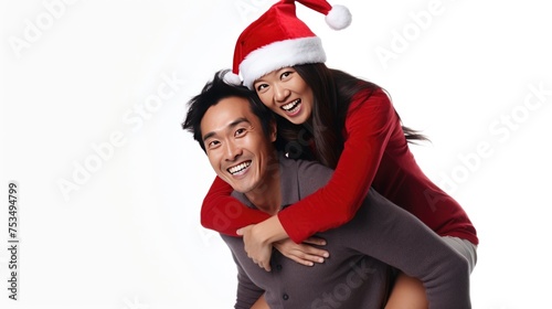A happy couple wearing Santa hats, hugging and smiling for the camera.