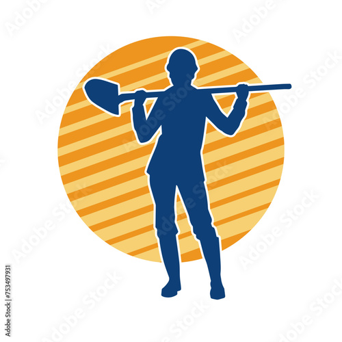 Silhouette of a female wearing worker costume in action pose with shovel tool.