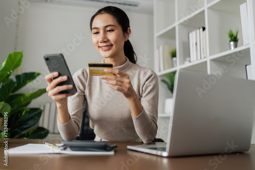 Young woman make a purchase on the Internet on the laptop and mobile with credit card