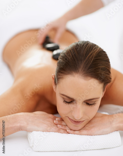 Relax, hot stone massage and woman at spa for health, wellness and luxury holistic treatment. Self care, peace and girl with natural body therapy, comfort and calm pamper service with hotel therapist