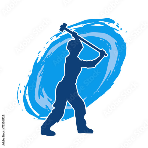 Silhouette of a worker in action pose using his sledge hammer tool.