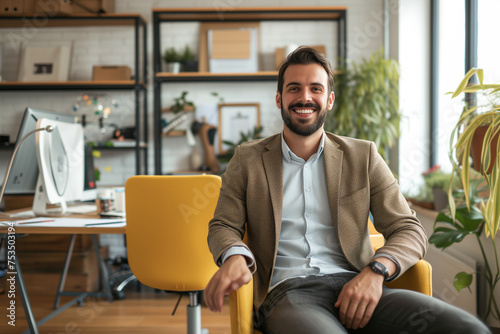 Portrait of a smiling businessman wearing blazar and sitting in minimal workplace, professional confident young man seated in office, Business man working in office room, The CEO sits in office chair
