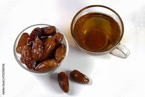 cup of tea and bowl of date fruits photo