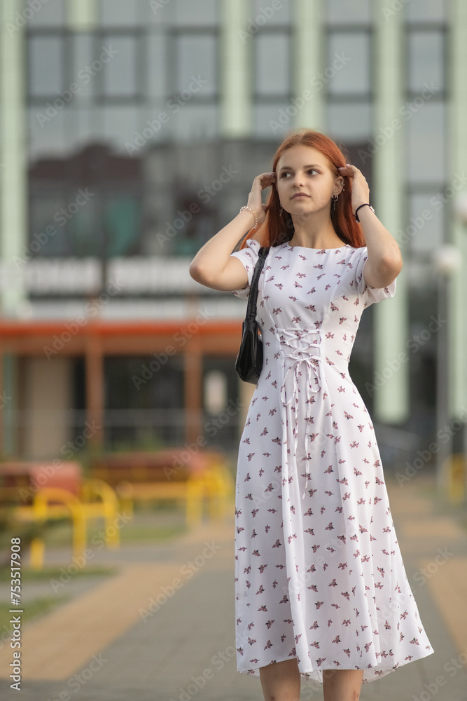 Portrait of a young beautiful red-haired girl in a dress in a summer park. Portrait of a young beautiful red-haired girl in a dress in a summer park.
