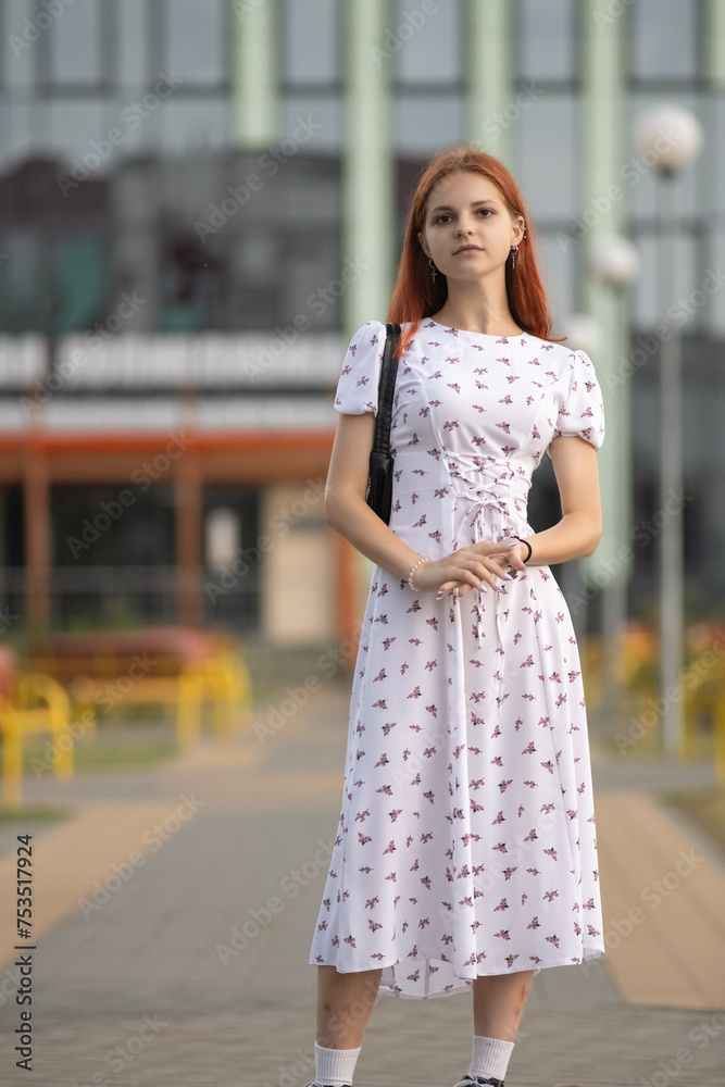 Portrait of a young beautiful red-haired girl in a dress in a summer park. Portrait of a young beautiful red-haired girl in a dress in a summer park.