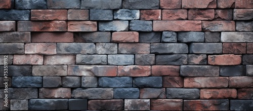 A brick wall constructed using bricks of various colors  presenting a unique and abstract texture. The bricks are cemented together to form a sturdy and visually striking barrier.