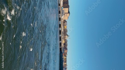 Stockholm's Skeppsbron and Nationalmuseum, blue water with ice floes, sunny day, vertical shot photo