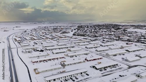 Snow covered Icelandic city in winter season. Selfoss Town with apartment houses and snowy roads. Aerial backwards shot.