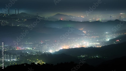 Looking from Datun Mountain, City is shrouded in a layer of white clouds and mist. Together with the city lights, it forms colorful glass light. photo