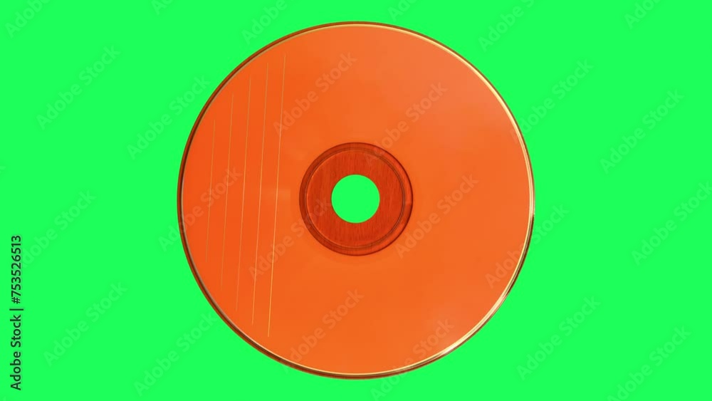 Orange CD or DVD spinning on the green screen. Top view.