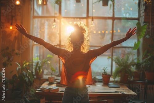 A joyful woman celebrates freely amidst the warm glow of sunlight streaming through a window