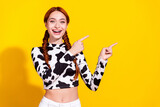 Photo of impressed excited woman wear cow skin top pointing two fingers empty space isolated yellow color background