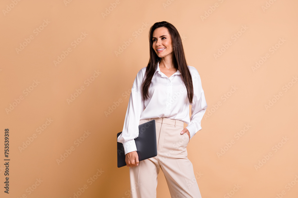 Fototapeta premium Photo of cheerful minded elegant girl hold netbook look empty space contemplate isolated on beige color background