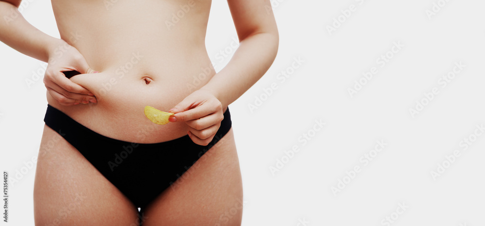 Overweight female body. Beautiful woman holding junk food in her hand. Body care, stretch marks and cellulite. Medicine and Cosmetology, Liposuction and Sports