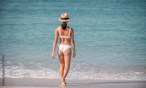 Sexy bikini woman wearing sunglass posing happiness on tropical beautiful beach is holiday lifestyle concept. photo