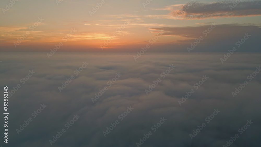 Orange cloudy sky horizon aerial view. Golden skyline over white fluffy clouds Orange cloudy sky horizon aerial view. Golden skyline over white fluffy clouds