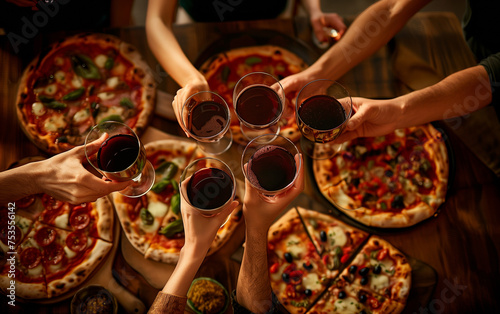 Friends Toasting Over Pizza Feast. An intimate gathering of hands toasting with red wine over a rustic spread of freshly baked pizzas, capturing a moment of camaraderie and culinary delight.