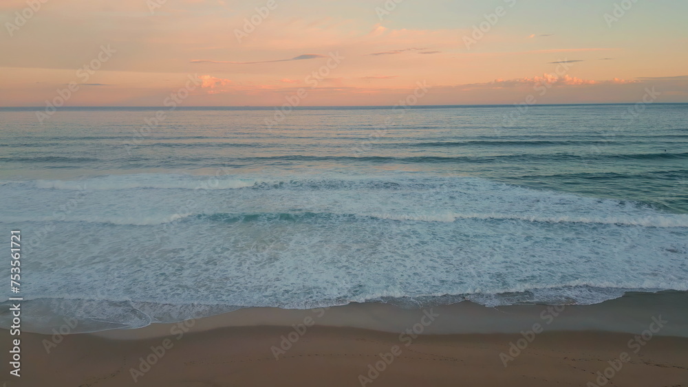 Orange sunset ocean horizon over foamy waves aerial view. Surf rolling coast