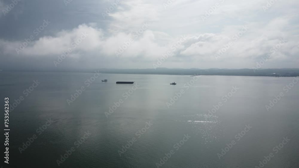 Aerial view of a tugboat towing an empty barge in the Kalimantan sea Aerial view of a tugboat towing an empty barge in the Kalimantan sea