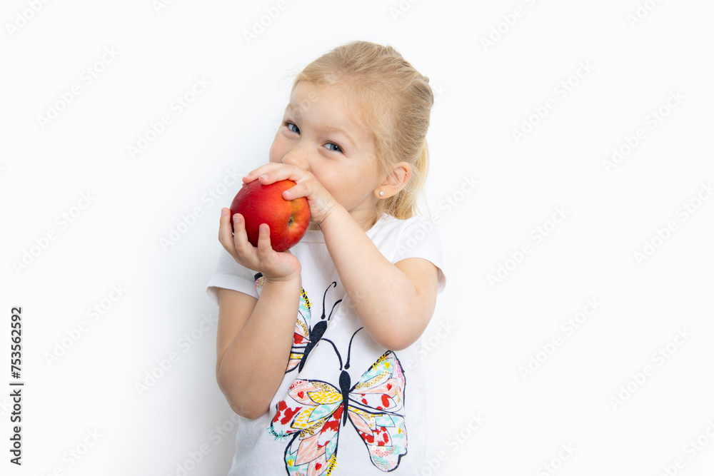 Smiling young blonde girl holding an apple on a white background Smiling young blonde girl holding an apple on a white background